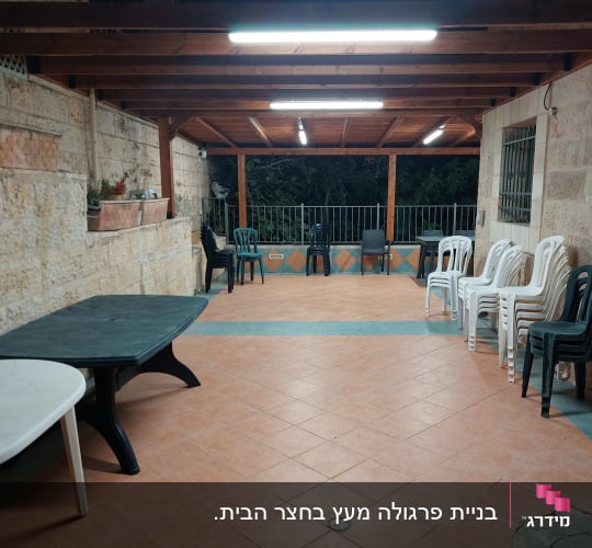 מרפסת עם גג עץ, שולחנות וכיסאות פלסטיק